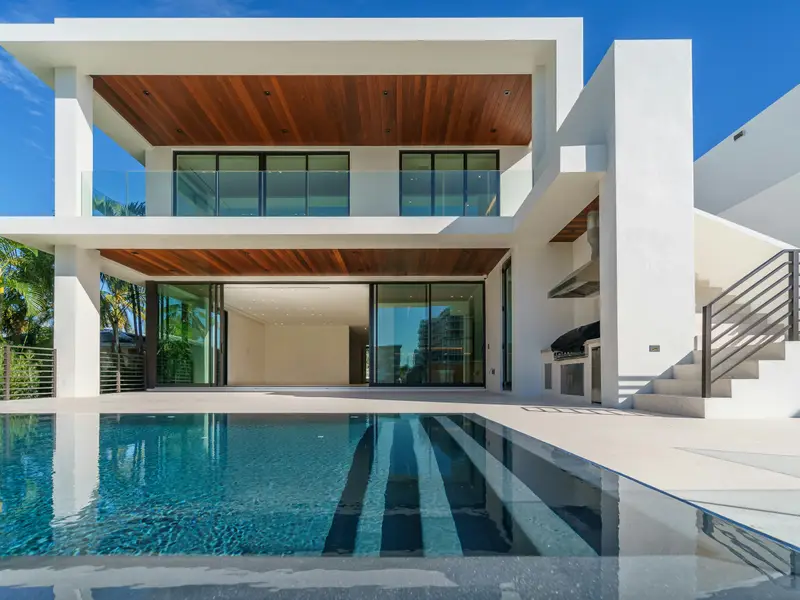 Modern villa with a pool and palms in the evening light